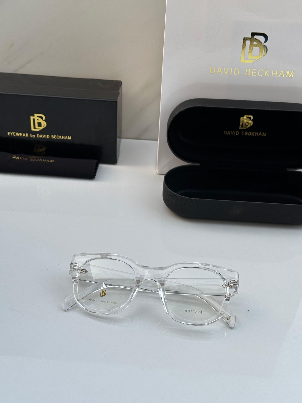 Clear eyeglasses with David Beckham logo on a white surface