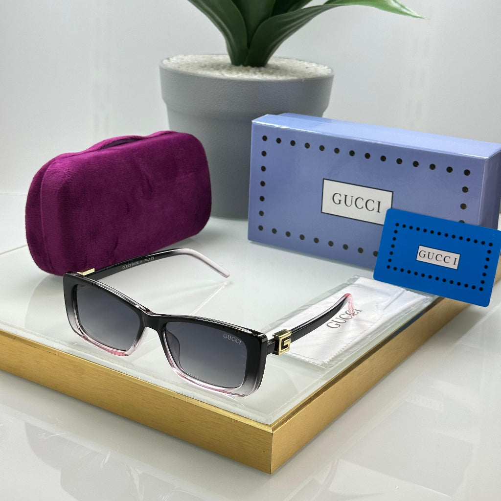 Sunglasses with a purple case and Gucci packaging on a white surface with a plant in the background